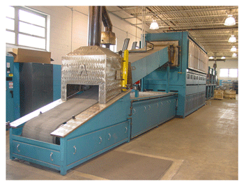 Fig. 2 -- This continuous-belt furnace is known as a “hump-back” continuous-belt furnace due to the elevated heating chamber (hot zone) shown in the photograph.