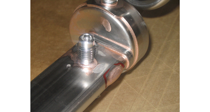 Fig. 9 This automotive fuel-rail was rejected by the customer because of too much applied BFM resulting in unacceptable-looking parts (poor aesthetics). Once the joint was filled, all the excess BFM had no-where to go, and so, ran down the surface of the part and pooled along the edge as a BFM “blob” (circled in red), and also on some of the other flat surfaces.