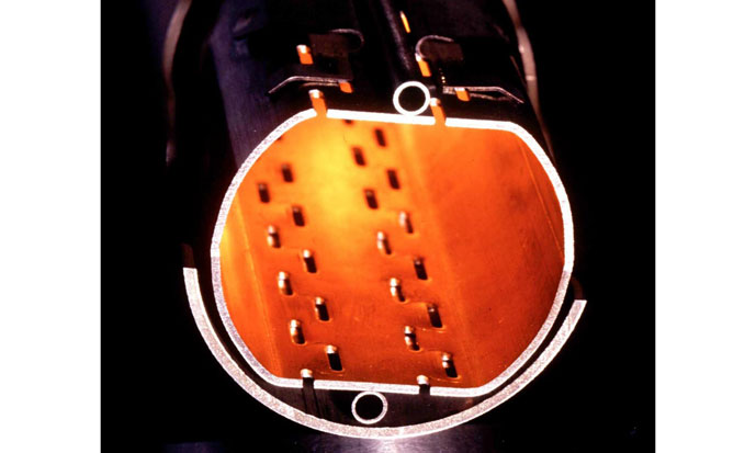 Figure 2 | Cross-section of LHC prototype beam pipes. The slits in the beam screen allow residual gas molecules to be pumped out to maintain the vacuum. The small round tubes carry liquid helium for cooling.1