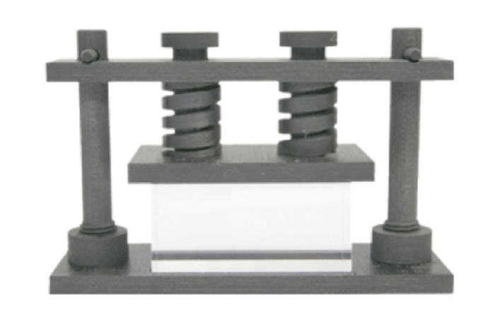 Fig. 8 - An example of a C/C fixture that uses round C/C springs to apply pressure to an assembly that would be fitted between the bottom plate and the plate on which the springs sit. Large amounts of effective pressure can be applied this way, rather than using dead-weights. Photo courtesy of Across USA, Inc.