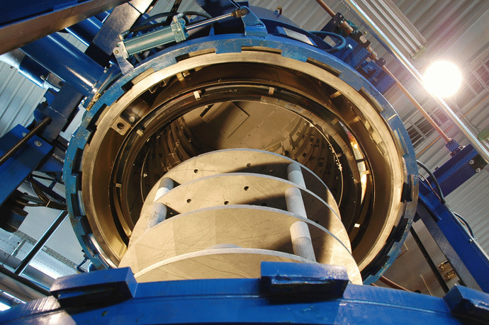 Ceramic parts fixture seen from below a bottom-loading vacuum furnace.