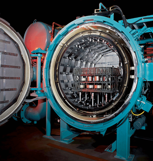 Horizontal vacuum furnace with an all-metal hot zone, containing parts placed in a custom fixture ready for processing.