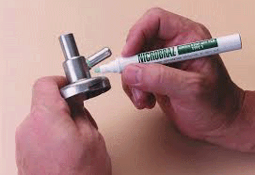 Fig. 3 -- Here is a photo of me using a stop-off “pen”, with a fibrous tip (like a felt-tip marker pen). This pen can be refilled many times, and its tip can also be replaced if it wears out. It’s a very convenient way to apply stop-off neatly and with no excess. (Photo when I used to work at Wall Colmonoy Corp., Detroit, MI)